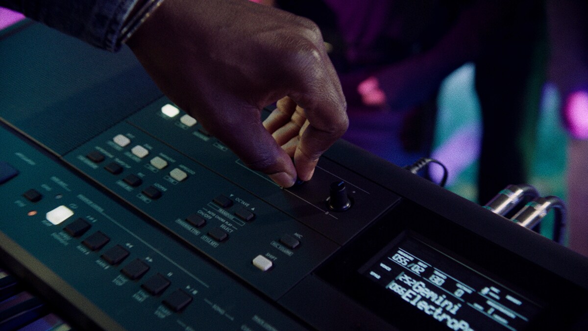 Eine Person steuert den Live-Steuerungs-Regler des PSR-E483