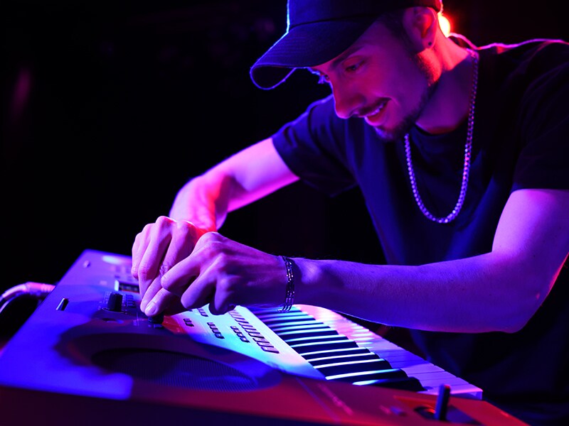 Ein Musiker stellt während eines Live-Auftritts die Live-Control-Regler an einem PSR-SX620 ein.