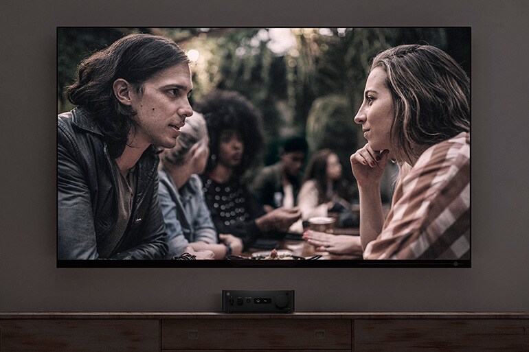 WXA-70A connected to a TV displaying a movie dialogue scene