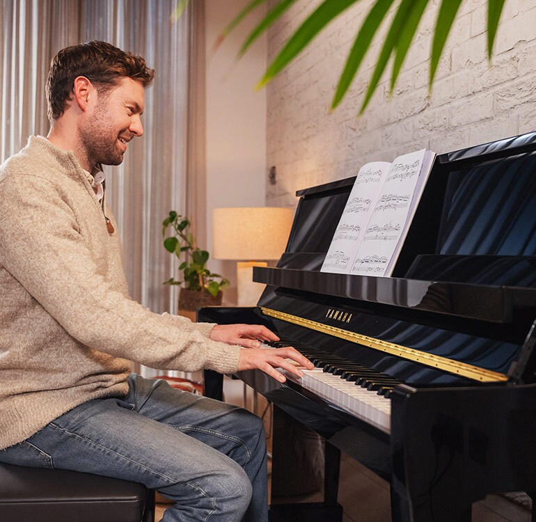 Eine Frau spielt mit Freude auf einem Klavier der B-Serie