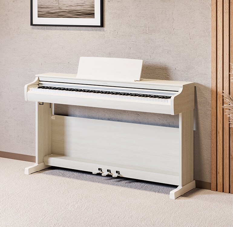 Ein Wohnzimmer mit einem ARIUS Piano in Weißer Birke, Zimmerpflanzen und einem Sofa, harmonisch in die Einrichtung integriert