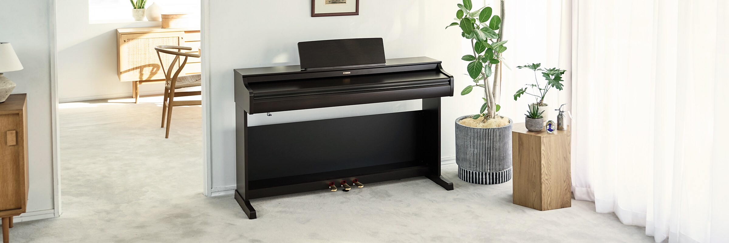 Ein ARIUS Piano mit geschlossenem Deckel in einem Wohnzimmer, das mit der Einrichtung verschmilzt.